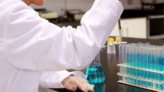 年轻科学家用吸管将化学物质放入试管中