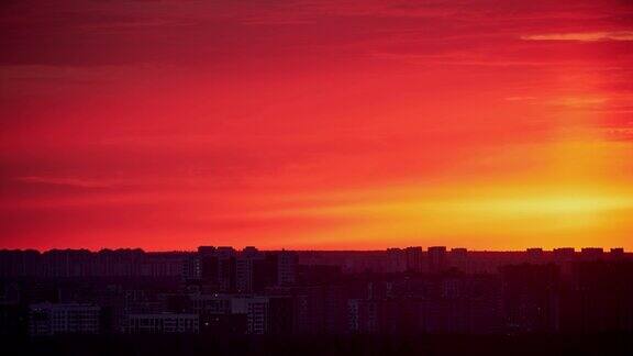 夕阳在红色的天空与晚霞在城市时间流逝夕阳西下照耀着高楼林立的城市