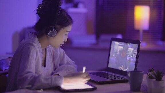 年轻的亚洲女性用笔记本电脑与在家工作到很晚的男同事进行虚拟会议