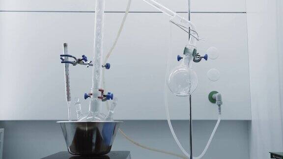 碗与玻璃烧瓶和温度计在左边液体缓慢地流入右边的烧瓶中蒸馏过程明亮的实验室化学反应实验室里的烧瓶4k