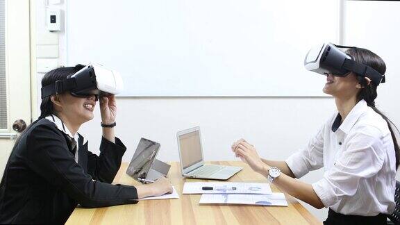 女商人在办公室的笔记本电脑上使用虚拟现实模拟眼镜