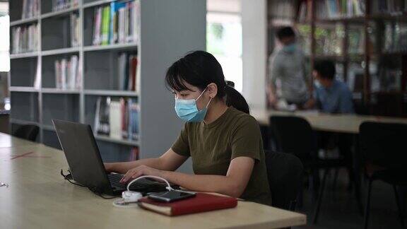 在图书馆学习的亚洲大学生观察社会距离