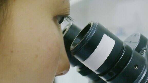 在医院实验室里摆弄显微镜的女科学家技术员