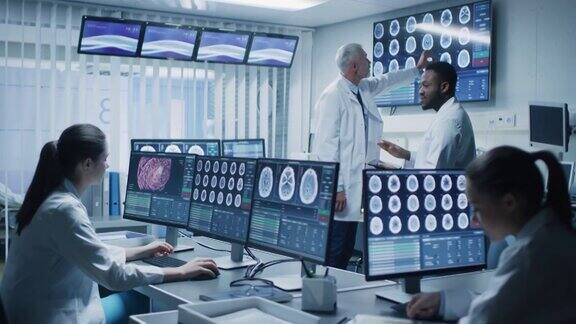 在大脑研究实验室工作的专业科学家团队神经学家神经科学家周围的显示器显示CTMRI扫描正在讨论和在个人电脑上工作