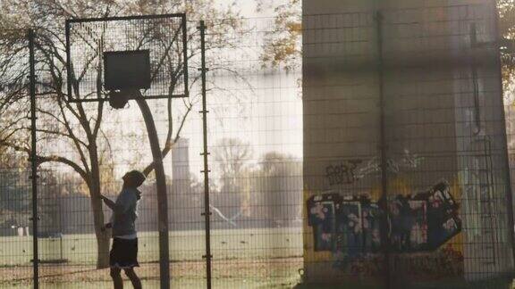 在篮筐里投篮球的运动型年轻人