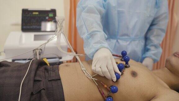 医院护士将电极固定在病人的四肢上用于心脏病学测试和设备医生正在为一名男性病人准备取心电图医生把电极固定在病人身上英斯达
