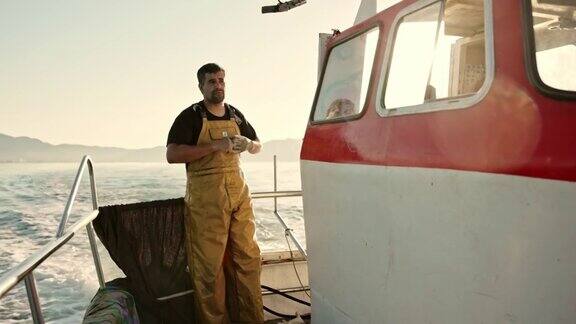 独立渔民在船上脱工作手套
