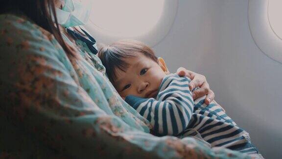 乘飞机旅行时男孩睡在母亲的怀里