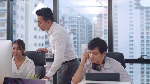 千禧一代年轻的亚洲商人和女商人在小型现代化都市办公室