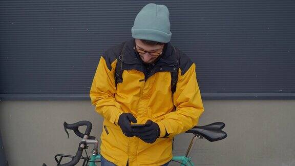 快递员靠在自行车上使用手机