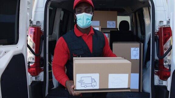 非洲男性快递员戴着防护口罩用卡车运送包裹