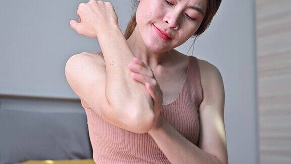 一名女子在肘部涂抹乳液以软化皮肤