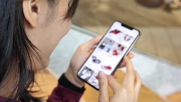 女人在网上服装店看商品智能手机网上购物慢镜头