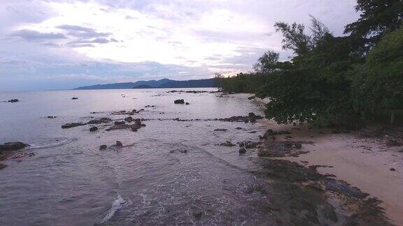 飞越热带海和岩石海滩黄昏航拍视频