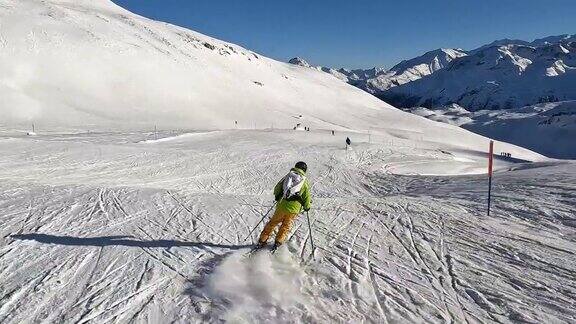 慢镜头:一个年轻人在阿尔卑斯山的滑雪坡上滑下坡