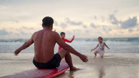 4K亚洲爷爷和孙子男孩和女孩一起在夏天日落的海滩上放松