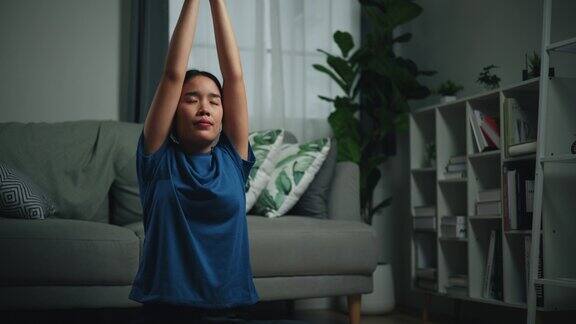 年轻的单身女子在客厅的地板上冥想和瑜伽