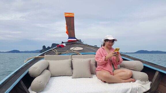 一名女子在帆船上使用智能手机