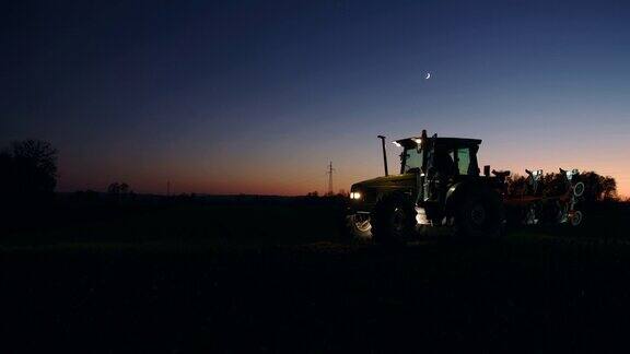 晚上一个面目人非的农民走回田里的拖拉机旁