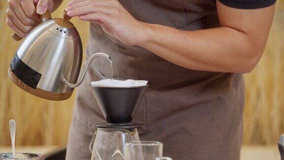 专业的咖啡师手动将水倒在过滤器中的咖啡渣上