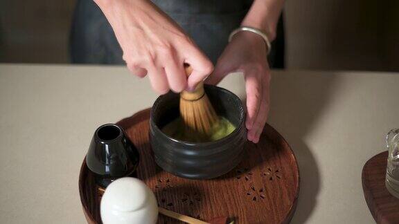 女人用竹打蛋器泡抹茶