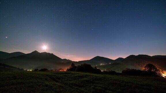 蓝色星空与星星和月亮的光在乡村乡村在高山景观天文时间流逝