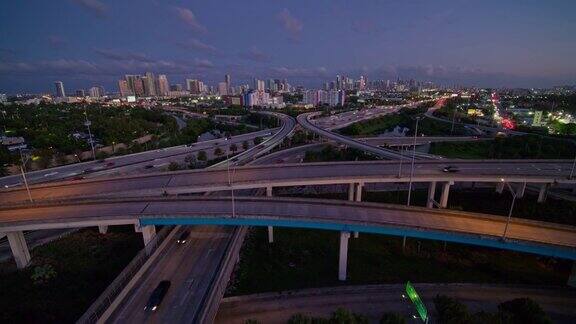 大而繁忙的高架交通枢纽州际95和I-195在北迈阿密与设计区和迈阿密市中心的远程视图在夜晚用超宽镜头无人机制作的b-roll镜头与下降的摄像机运动