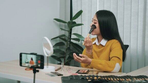 一位年轻的亚洲女性在博客上展示她的化妆品与朋友分享她的专业精神