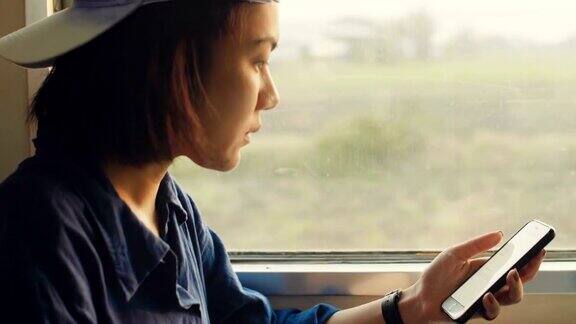 亚洲女性在火车上使用智能手机和笔记本电脑