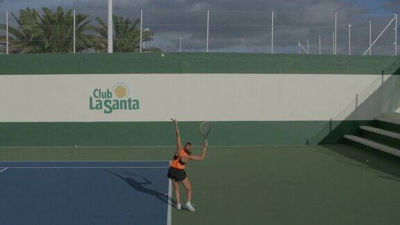 一位年轻女子打网球时发球动作是慢动作