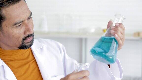 科学家手持装有彩色液体的试管实验室助理比较试管中的样品在实验室从事生物化学或化学研究分析实验室的细菌检验结果
