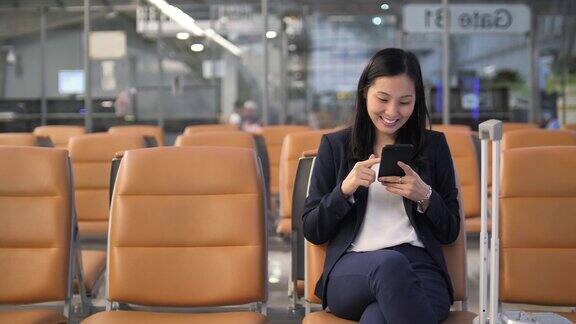 女商人在机场使用手机