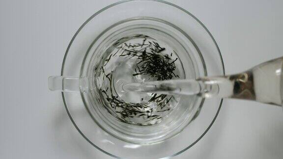 俯视图:将水倒在玻璃杯中的绿茶上