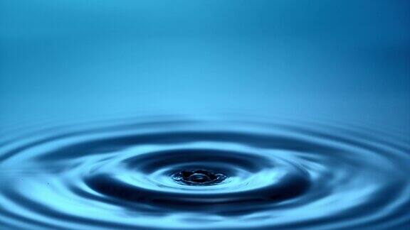 一滴水滴落进蓝色的水里