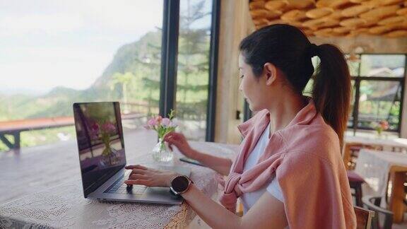 自由数字游牧民会计和记账微笑在咖啡馆打电话而旅行女性写作内容工作远程笔记本电脑制造被动进来