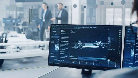 专业工程师使用3DCAD软件在电脑上工作并在高科技开发实验室测试电动汽车的底盘原型包括车轮、电池和发动机