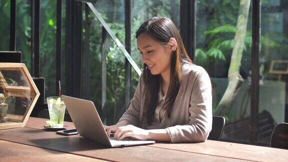 在咖啡馆使用笔记本电脑的亚洲女人