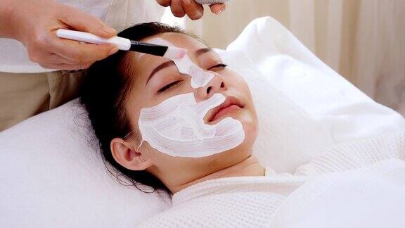 亚洲女性在接受面部护理时可以在脸上敷面膜做Spa