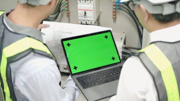 工业工程师使用绿色模拟屏幕在个人电脑上工作
