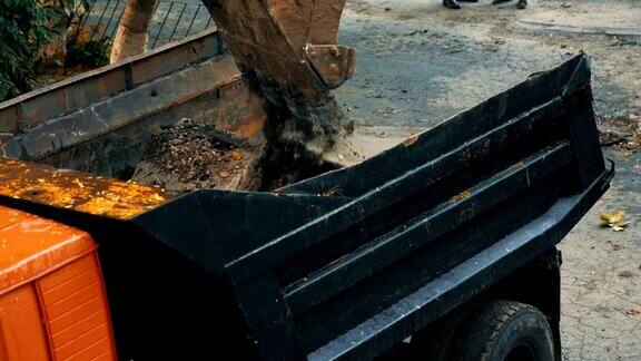 道路施工挖掘机装载沥青碎石的卡车