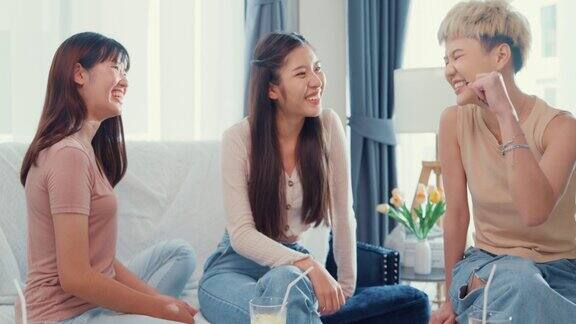 年轻的亚洲女性朋友坐在家里的沙发上聊天一起度过周末