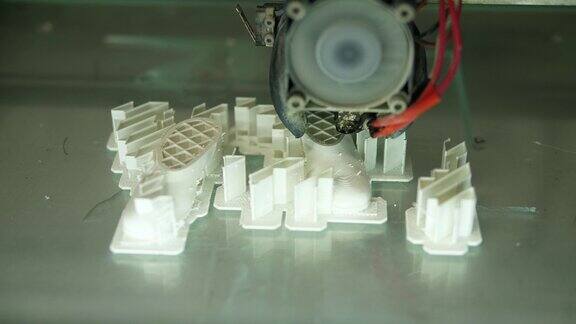 正在工作的3D打印机正在用白色塑料打印物体