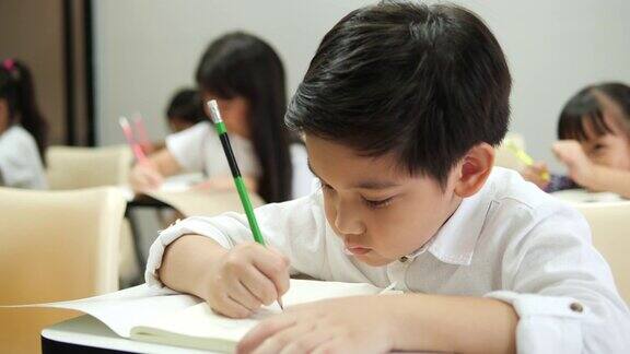 亚洲的孩子们在学校的教室里一起学习和写作教育