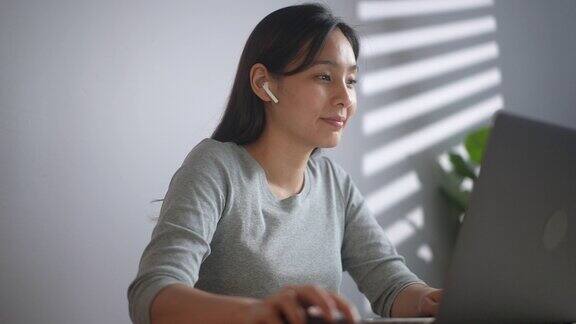 在家里使用笔记本电脑的亚洲女性