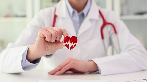 心脏病专家医生手里拿着红色的心脏图标特写