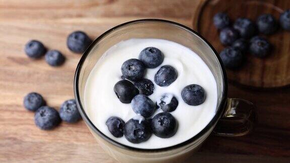 新鲜的酸奶和蓝莓放在一个玻璃碗里放在桌子上