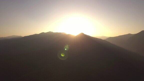 航拍:飞到山顶后日出背景是晴朗的天空