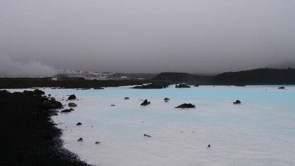 冰岛Reykjanes半岛Grindavík附近的Svartsengi地热发电厂由黑色熔岩包围的游泳池中蓝色闪烁的热水