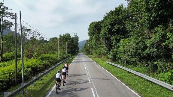 无人机在农村地区观看公路旅行3名亚洲中国女自行车手在早上骑自行车
