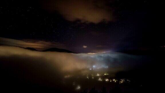 星星与银河和波浪的薄雾在夜晚村庄时间流逝